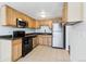 Functional kitchen features wood cabinets, black appliances and light countertops at 969 S Pearl St # 103, Denver, CO 80209