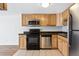 Well-lit kitchen includes stainless steel refrigerator, and wood cabinets at 969 S Pearl St # 103, Denver, CO 80209