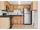Well-lit kitchen features wood cabinets, granite countertops, and stainless-steel appliances at 969 S Pearl St # 103, Denver, CO 80209