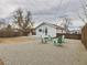 Wide backyard of a white home, with a patio, wooden fence, some gravel and outdoor chairs at 3150 S Pennsylvania Street, Englewood, CO 80113