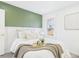 Comfortable bedroom with a soft green accent wall, plush bedding, and natural light at 3150 S Pennsylvania Street, Englewood, CO 80113