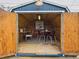 The blue home office shed features a desk, dining table, rug, and lighting, creating a comfortable and functional workspace at 3150 S Pennsylvania Street, Englewood, CO 80113