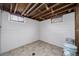 Unfinished basement area with tiled floor and exposed beams at 1017 Florence St, Aurora, CO 80010