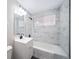 Updated bathroom with marble tile, bathtub, and modern vanity at 1017 Florence St, Aurora, CO 80010