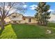 View of the grassy backyard and brick patio of the two-story home at 814 Glenwood Dr, Lafayette, CO 80026