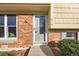 Close-up of a front door with brick siding, a glass storm door, and the house number clearly visible at 814 Glenwood Dr, Lafayette, CO 80026