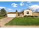 Inviting home with a well-manicured lawn, attached garage, and a mix of brick and vinyl siding at 814 Glenwood Dr, Lafayette, CO 80026