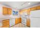 Kitchen with light wood cabinets, white appliances, and ceramic tile flooring at 814 Glenwood Dr, Lafayette, CO 80026