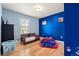 Bright blue bedroom with hardwood floors, ample natural light, and playful decor at 4814 Monarch Dr, Firestone, CO 80504