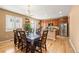 Eat-in kitchen area featuring hardwood floors, a table for six, and ample natural light at 4814 Monarch Dr, Firestone, CO 80504