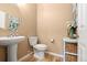 Charming powder room featuring a pedestal sink, decorative mirror, and stylish décor at 4814 Monarch Dr, Firestone, CO 80504