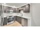 Modern kitchen with stainless steel appliances, stylish cabinets, and quartz countertops at 6485 S Havana St # A, Englewood, CO 80111