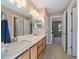 Bathroom featuring double sinks, quartz countertop, wood cabinets and views into the adjacent bedroom at 10610 Winterflower Way, Parker, CO 80134