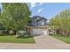 Charming two-story home with blue siding, stone accents, a two car garage, and mature landscaping at 10610 Winterflower Way, Parker, CO 80134