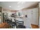 Bright kitchen with white cabinetry, stainless appliances, and a large island with bar seating at 10610 Winterflower Way, Parker, CO 80134