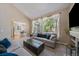 Bright living room featuring large windows, neutral paint, and hardwood floors, leading to the kitchen at 10610 Winterflower Way, Parker, CO 80134