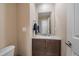 Neutral powder room with single sink vanity, granite counters, and a decorative towel set at 10610 Winterflower Way, Parker, CO 80134