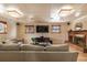 Finished basement with a cozy brick fireplace, plush seating, and a large TV at 10902 Bannock St, Northglenn, CO 80234