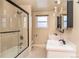 Bathroom featuring double sinks, and a glass-enclosed shower, all brightly lit at 10902 Bannock St, Northglenn, CO 80234