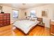 Bright bedroom with hardwood floors, a modern bed frame, and two large windows at 10902 Bannock St, Northglenn, CO 80234