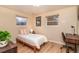 Bright bedroom with natural light, featuring wood floors, a comfortable bed, and a cozy workspace at 10902 Bannock St, Northglenn, CO 80234