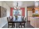 Dining room with large wooden table, modern chandelier, and sliding door to backyard at 10902 Bannock St, Northglenn, CO 80234