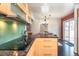 Kitchen with stainless cooktop, granite countertops, bright green backsplash, and modern cabinetry at 10902 Bannock St, Northglenn, CO 80234