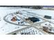 Aerial view of a community park in winter, featuring a playground, picnic shelter, benches, and walking paths at 10902 Bannock St, Northglenn, CO 80234