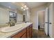 Bathroom featuring double sinks, granite countertops, tiled floors, and a glass-enclosed shower at 14921 W 70Th Ave, Arvada, CO 80007