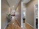 Long hallway with wood floors connecting the home's spaces, with a view into a bedroom and the living room at 14921 W 70Th Ave, Arvada, CO 80007