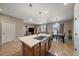 Open-concept kitchen island with sink, blending into the living and dining areas, all with wood flooring at 14921 W 70Th Ave, Arvada, CO 80007