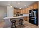 A well-lit kitchen with wood cabinets, stainless steel appliances, and a breakfast bar at 14921 W 70Th Ave, Arvada, CO 80007