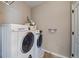 Bright laundry room featuring a side-by-side washer and dryer and storage space at 14921 W 70Th Ave, Arvada, CO 80007