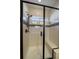 Modern tiled shower with a glass door, rainfall showerhead, built-in bench, and decorative accent tiles at 14921 W 70Th Ave, Arvada, CO 80007