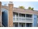 Building exterior featuring blue siding, stone chimney and a white balcony at 8335 Fairmount Dr # 9-206, Denver, CO 80247