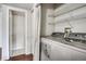 Efficient laundry room featuring modern side-by-side washer and dryer with shelving at 8335 Fairmount Dr # 9-206, Denver, CO 80247