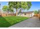 Large, green backyard featuring mature shade tree, and a white brick home with a patio at 127 Emerald St, Broomfield, CO 80020