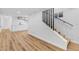 Finished basement featuring wood floors, a staircase with black railings, and sleek white cabinets at 127 Emerald St, Broomfield, CO 80020