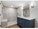 Bathroom featuring elegant vanity with gold accents, a modern shower with marble tile, and bench at 127 Emerald St, Broomfield, CO 80020