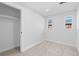 Bedroom featuring neutral carpet, white walls and trim, closet and two windows at 127 Emerald St, Broomfield, CO 80020