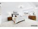 Staged bedroom with neutral decor, including a bed, side tables, dresser, and mirror at 127 Emerald St, Broomfield, CO 80020