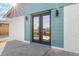 Close-up of the stylish double front doors with glass panels, set against a white brick and teal exterior at 127 Emerald St, Broomfield, CO 80020