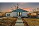 Charming home featuring a well-manicured lawn, landscaped bushes and concrete walkway at sunset at 127 Emerald St, Broomfield, CO 80020