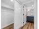 Hallway to bathroom includes a closet with sliding doors and wood style flooring at 127 Emerald St, Broomfield, CO 80020