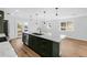 Bright kitchen with a large island, stainless steel appliances, green cabinets, and hardwood flooring at 127 Emerald St, Broomfield, CO 80020