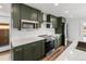 Modern kitchen featuring stylish green cabinets, stainless steel appliances, and quartz countertops at 127 Emerald St, Broomfield, CO 80020