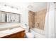 This bathroom offers a shower over tub with tan tiled wall, wood vanity, and a white sink at 1313 N Williams St # 1003, Denver, CO 80218