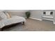 Comfortable bedroom includes a window seat, a small window, neutral carpet, a bed and a potted houseplant at 2560 Champa St, Denver, CO 80205