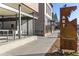 Exterior street view with modern architecture and artistic metal signage for directions on a clear, sunny day at 2560 Champa St, Denver, CO 80205