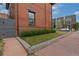 Red brick building features a small, well-maintained lawn with shrubbery along the building's foundation at 2560 Champa St, Denver, CO 80205